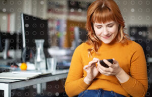 A woman connecting with people on her phone at work.